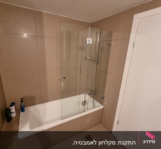 אמבטיה עם דלת זכוכית ומקלחת יד